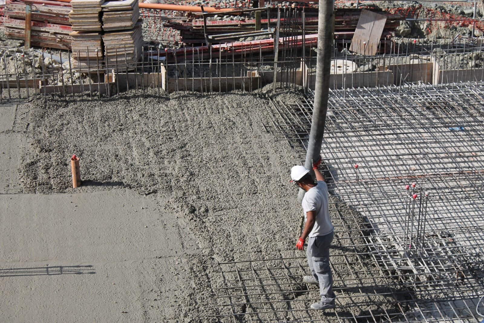 Construction worker pouring and finishing concrete slab, Mughal Sons project